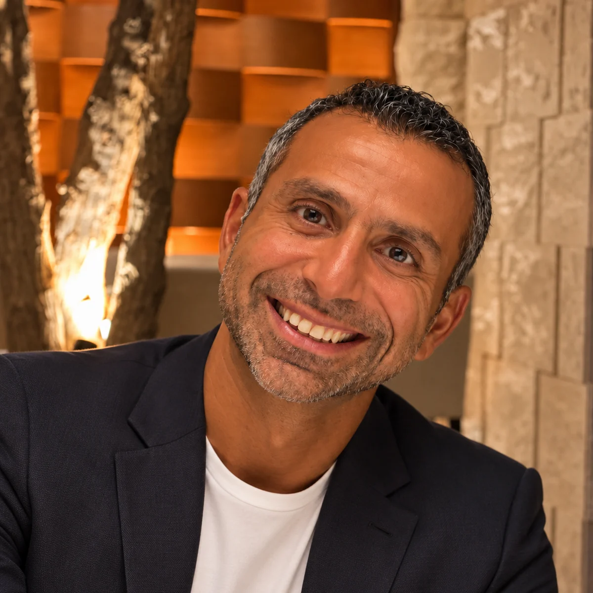 Hady Amer smiling in a navy blazer